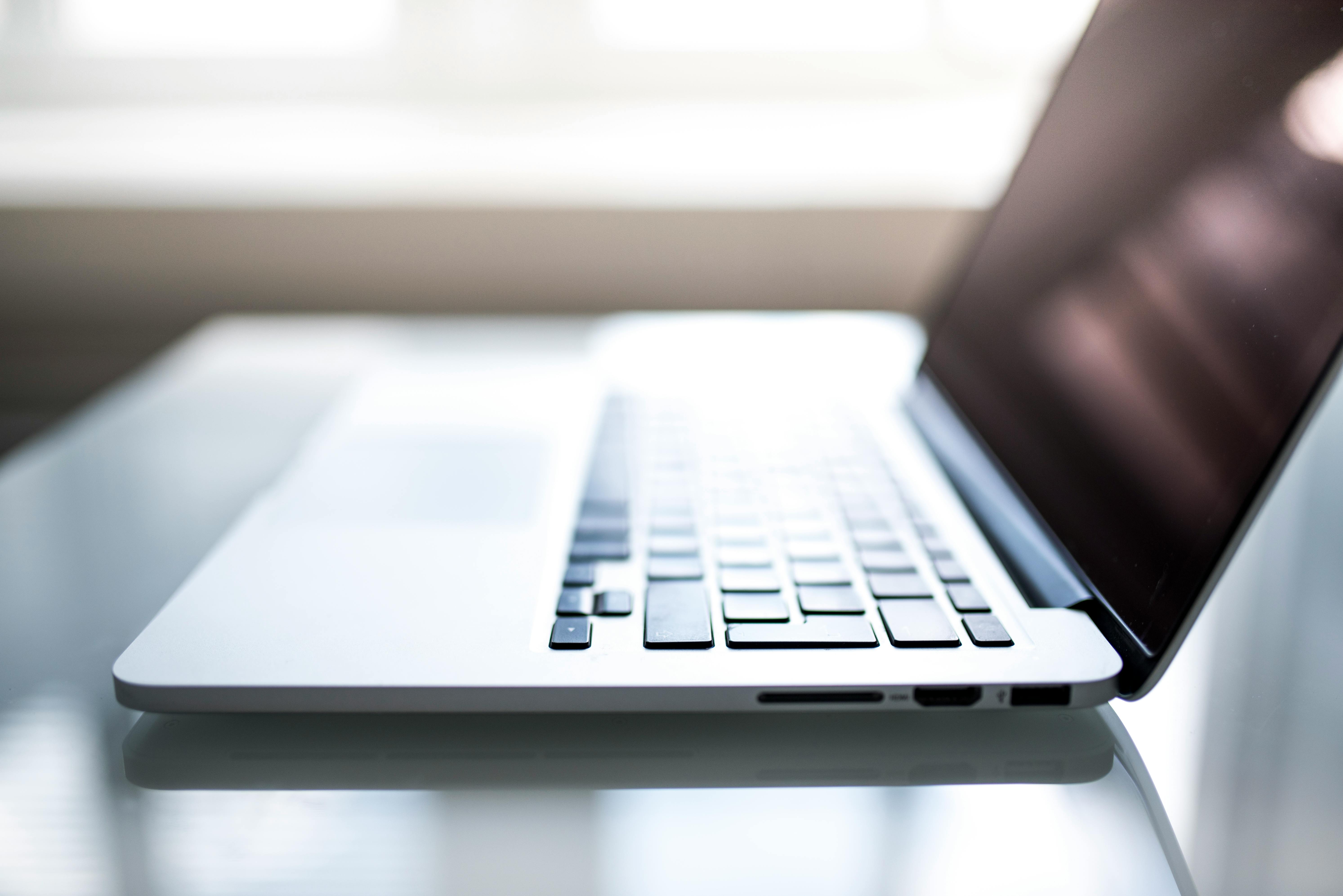 Elegant side view of a laptop on a glossy table with natural lighting indoors.